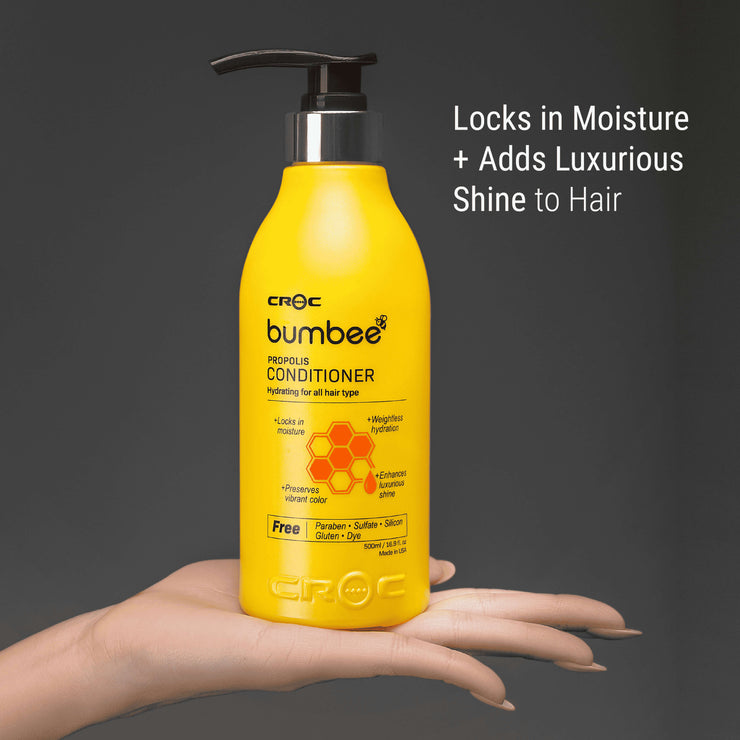 Hand holding Bumbee Propolis Conditioner, 500ml, showcasing moisture-lock and shine enhancement for hair