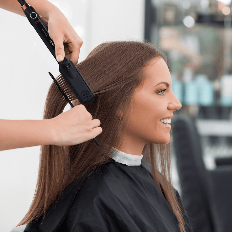 Hair Stylist Flat Irons Hair on a Woman in Hair Salon